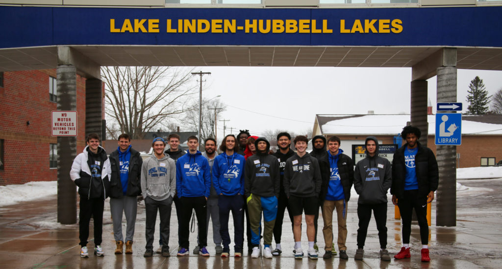 Finlandia Lions Men's Basketball Team stand for group photo outside Lake Linden-Hubbell Elementary School on MLK Day of Service 2023